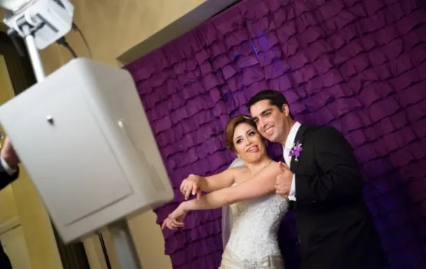Wedding guests posing with fun props at photo booth